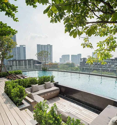Luxurious rooftop pool with stunning city skyline views and lush greenery.