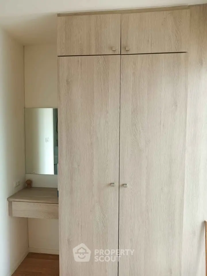 Spacious wooden wardrobe with built-in vanity in modern apartment