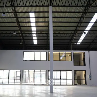 Spacious industrial warehouse interior with high ceilings and large windows