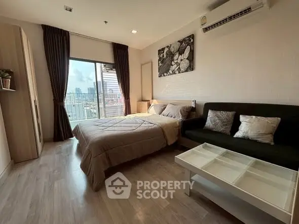 Modern bedroom with city view, featuring cozy bed and stylish decor.
