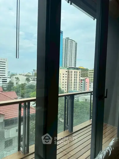 Stunning city view from a modern apartment balcony with sleek glass doors.