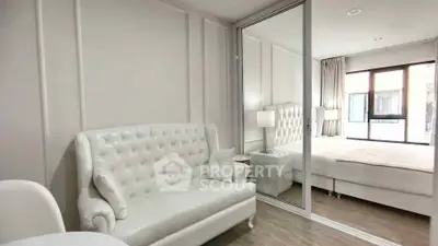 Luxurious white bedroom with elegant tufted sofa and mirrored wardrobe