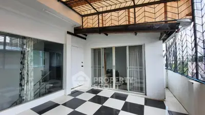 Spacious balcony with checkered flooring and sliding glass doors in modern home.