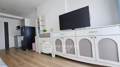 Modern living room with stylish furniture and large TV in a cozy apartment.