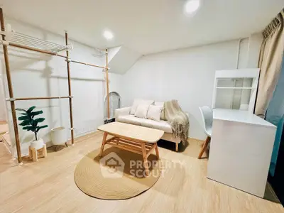 Cozy living room with modern decor and natural light, featuring a stylish sofa and workspace.