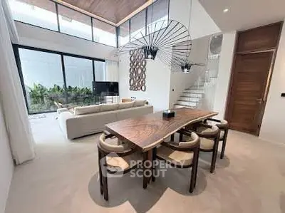 Luxurious open-plan living and dining area with high ceilings and modern decor.