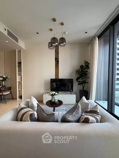 Modern living room with stylish decor and large windows offering city views.