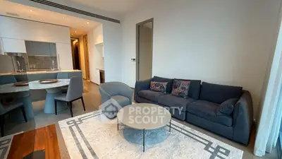 Modern living room with stylish furniture and open kitchen layout in a contemporary apartment.