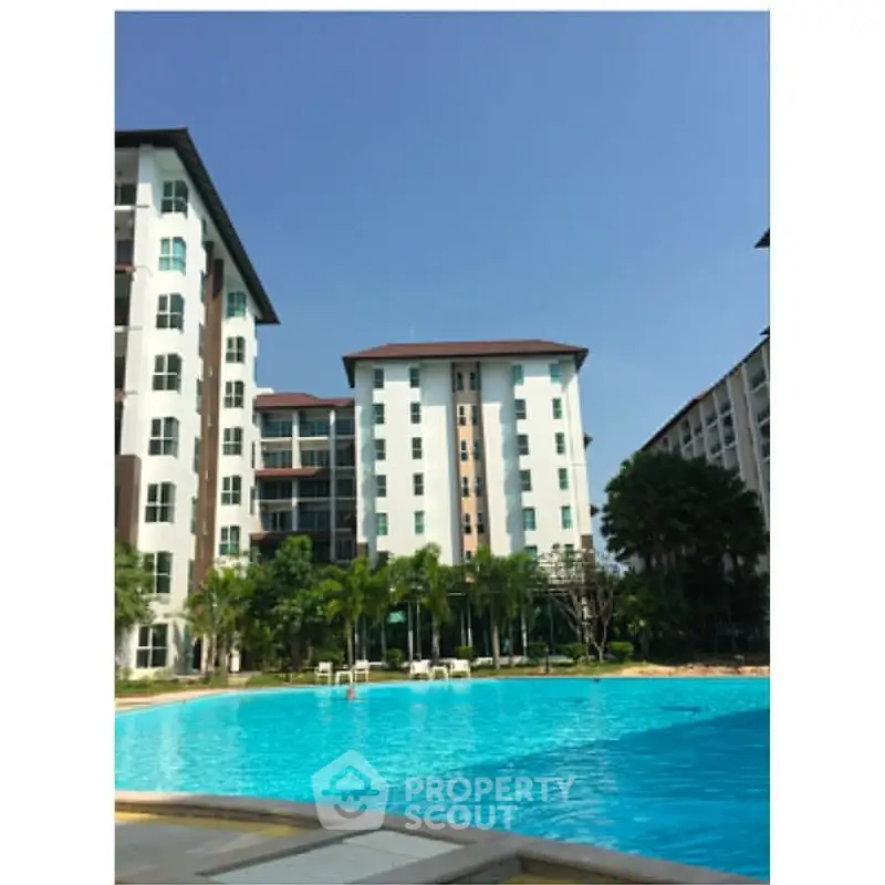 Luxurious condominium with a stunning pool and lush greenery, perfect for relaxation and leisure.