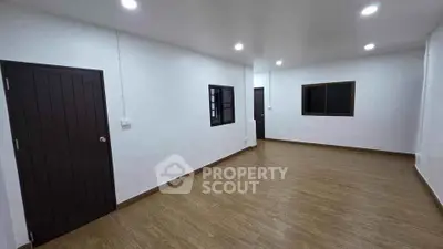 Spacious empty room with wooden flooring and modern lighting, ideal for customization.