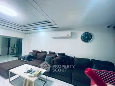 Spacious modern living room with stylish brown sofa and wall-mounted air conditioner