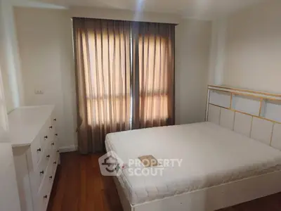 Cozy bedroom with natural light and elegant furnishings, perfect for relaxation and comfort.