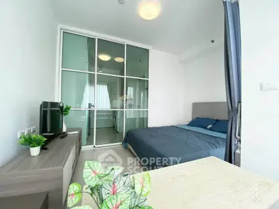 Modern bedroom with glass partition and stylish decor in a bright apartment.