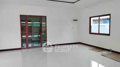 Spacious unfurnished living room with large windows and glossy tiled floor.