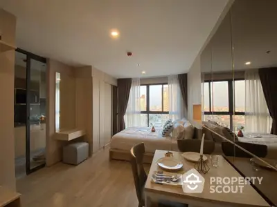 Modern bedroom with city view, elegant decor, and cozy dining area in a high-rise apartment.