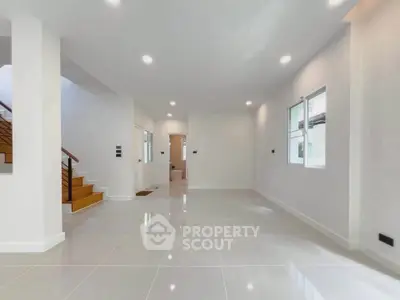 Spacious modern living room with glossy tile flooring and ample natural light.