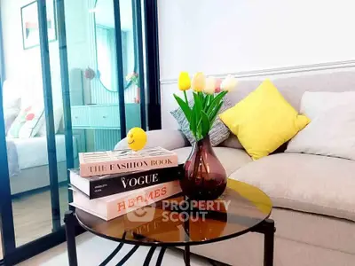 Stylish living room with modern decor and glass partition, featuring a cozy sofa and elegant coffee table.