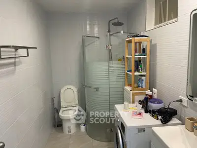 Modern bathroom with glass shower and washing machine in sleek design
