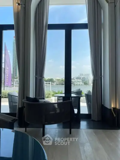 Luxurious interior with large windows offering stunning waterfront views, elegant furniture, and modern decor.