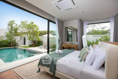 Luxurious bedroom with pool view in modern villa, featuring elegant decor and large glass doors opening to a serene garden.