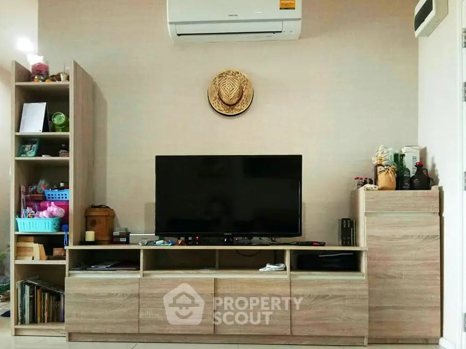Modern living room with stylish wooden TV stand and air conditioning unit.