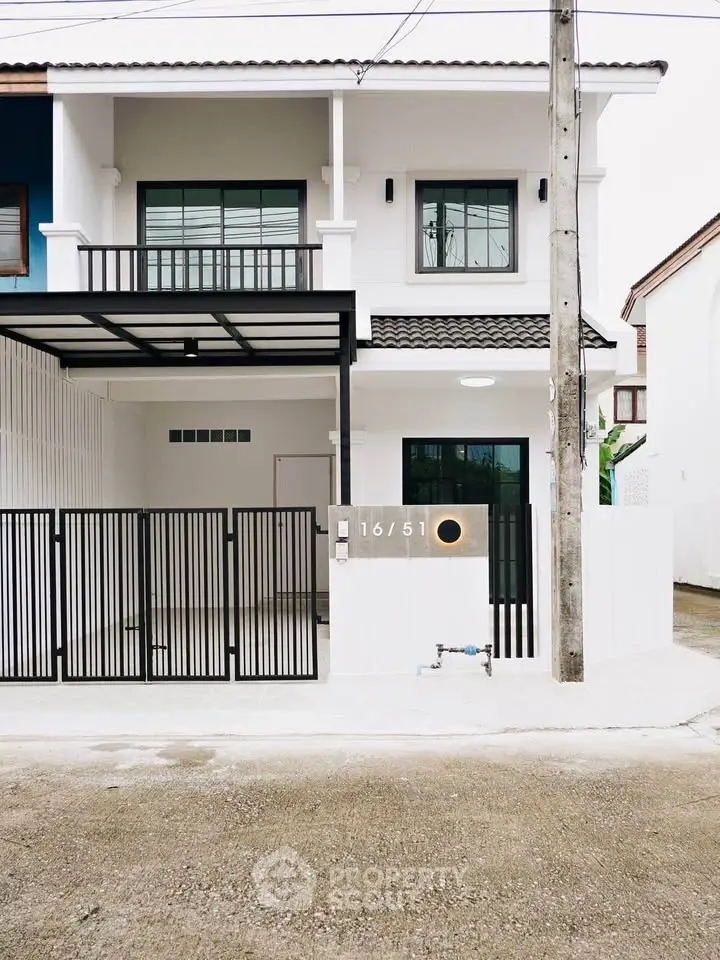 Modern two-story house with gated entrance and sleek design, perfect for contemporary living.