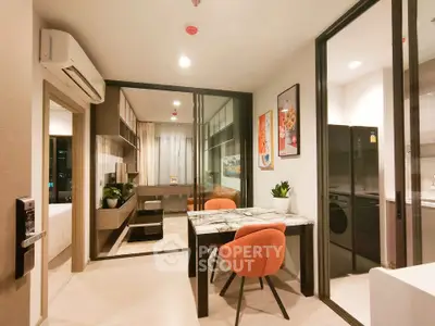 Modern open-plan living and dining area with stylish decor and kitchen view.