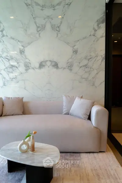 Elegant living room with marble accent wall and modern sofa