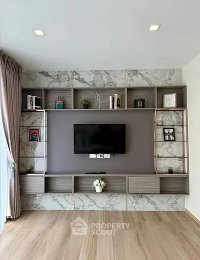 Modern living room with stylish built-in shelving and mounted TV, featuring elegant marble accents and wooden flooring.