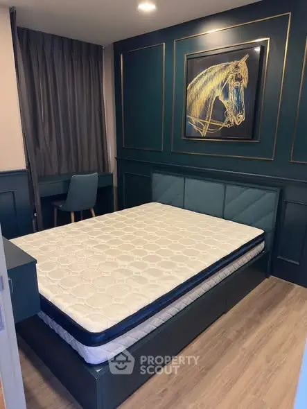 Elegant bedroom with modern decor and stylish artwork, featuring a comfortable bed and cozy workspace.