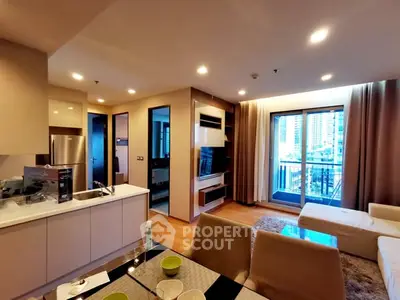 Modern open-layout living room with kitchen and balcony view in urban apartment