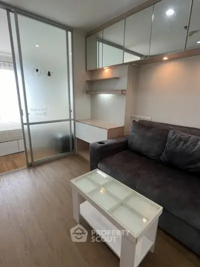 Modern living room with cozy sofa and glass coffee table in stylish apartment.