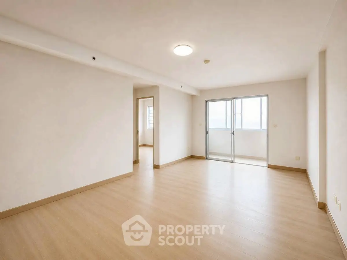 Spacious unfurnished living room with wooden flooring and large windows for natural light.