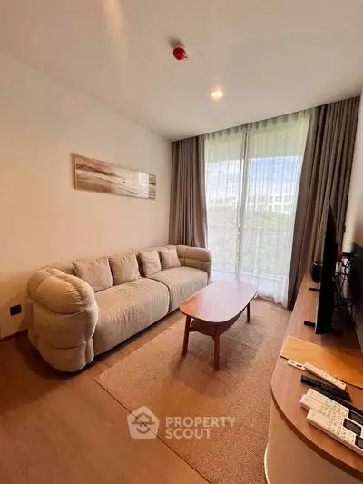 Cozy living room with plush sofa, wooden coffee table, and large window with curtains.