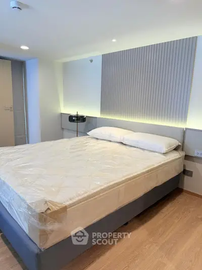 Modern bedroom with stylish lighting and cozy bed in contemporary apartment.