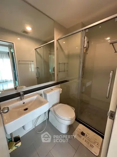 Modern bathroom with glass shower and sleek fixtures in a contemporary apartment.