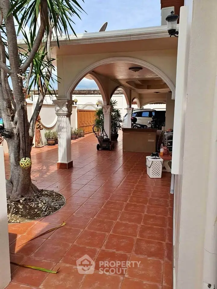Charming Mediterranean-style patio with terracotta tiles and lush greenery.