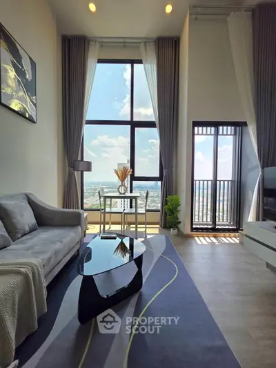 Modern living room with large windows and stunning city view, featuring contemporary furniture and sleek design.