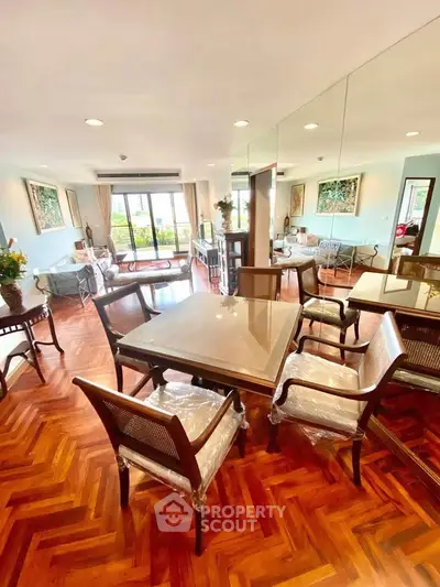 Spacious living room with elegant dining area and large windows offering natural light.