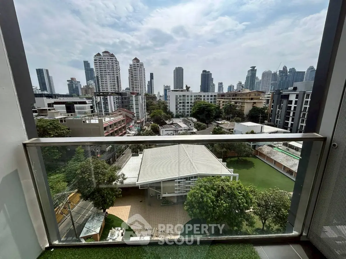 Stunning cityscape view from a modern balcony overlooking urban skyline and greenery.