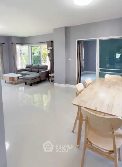 Spacious modern living room with dining area and large windows for natural light.