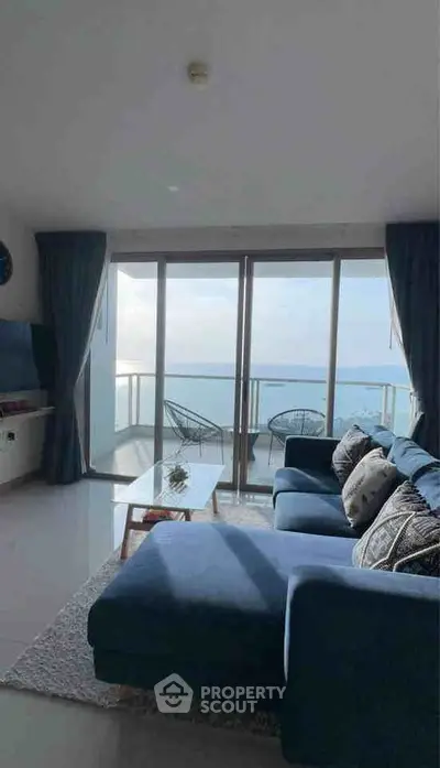 Stunning living room with ocean view and modern blue sofa, perfect for relaxation.