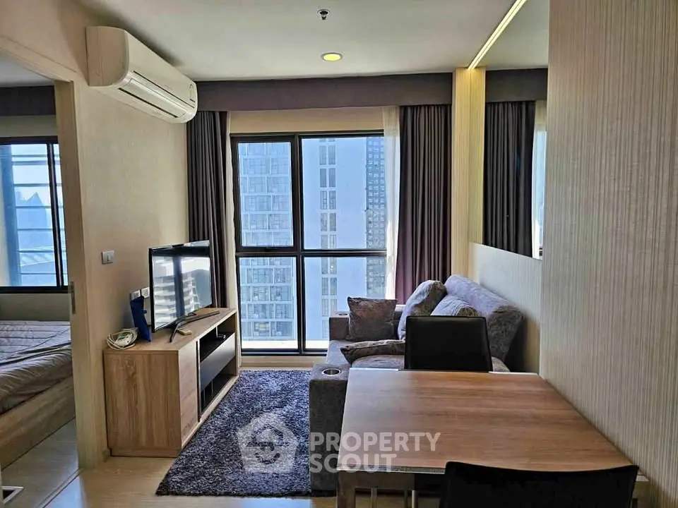 Modern living room with city view, cozy seating, and natural light in a stylish apartment.