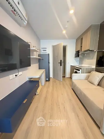 Modern living room with sleek furniture and open kitchen layout in a stylish apartment.