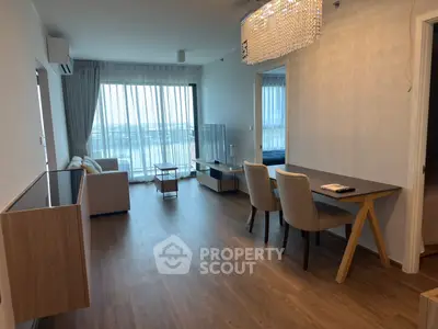 Modern living room with elegant dining area and stunning view, featuring hardwood floors and chic lighting.