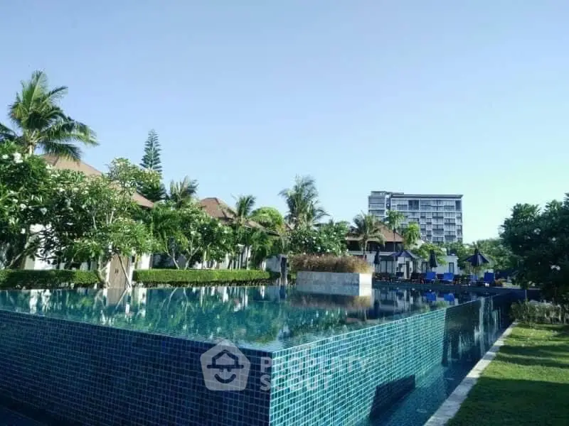 Luxurious poolside view with lush greenery and modern architecture, perfect for resort-style living.