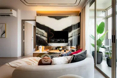 Luxurious modern living room with stylish decor and large windows opening to a balcony.