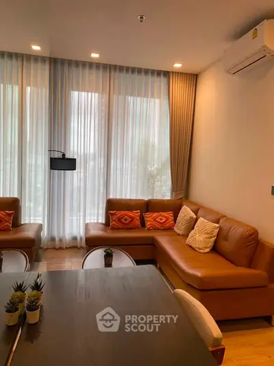 Modern living room with stylish brown leather sofa and elegant decor