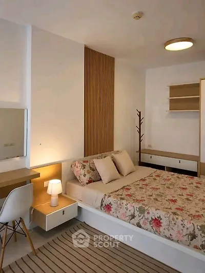 Cozy bedroom with modern decor and floral bedding in a stylish apartment.