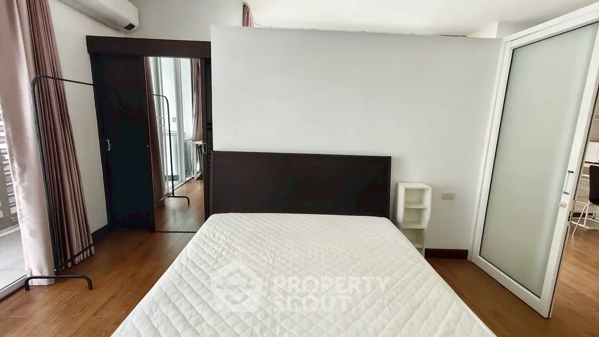 Spacious bedroom with modern design and balcony access in a stylish apartment.